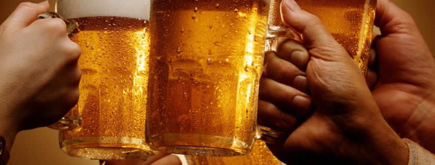 FOUR HANDS MALE AND FEMALE TOAST WITH MUGS OF BEER