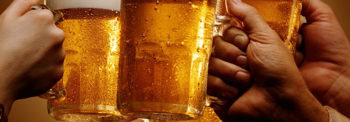 FOUR HANDS MALE AND FEMALE TOAST WITH MUGS OF BEER